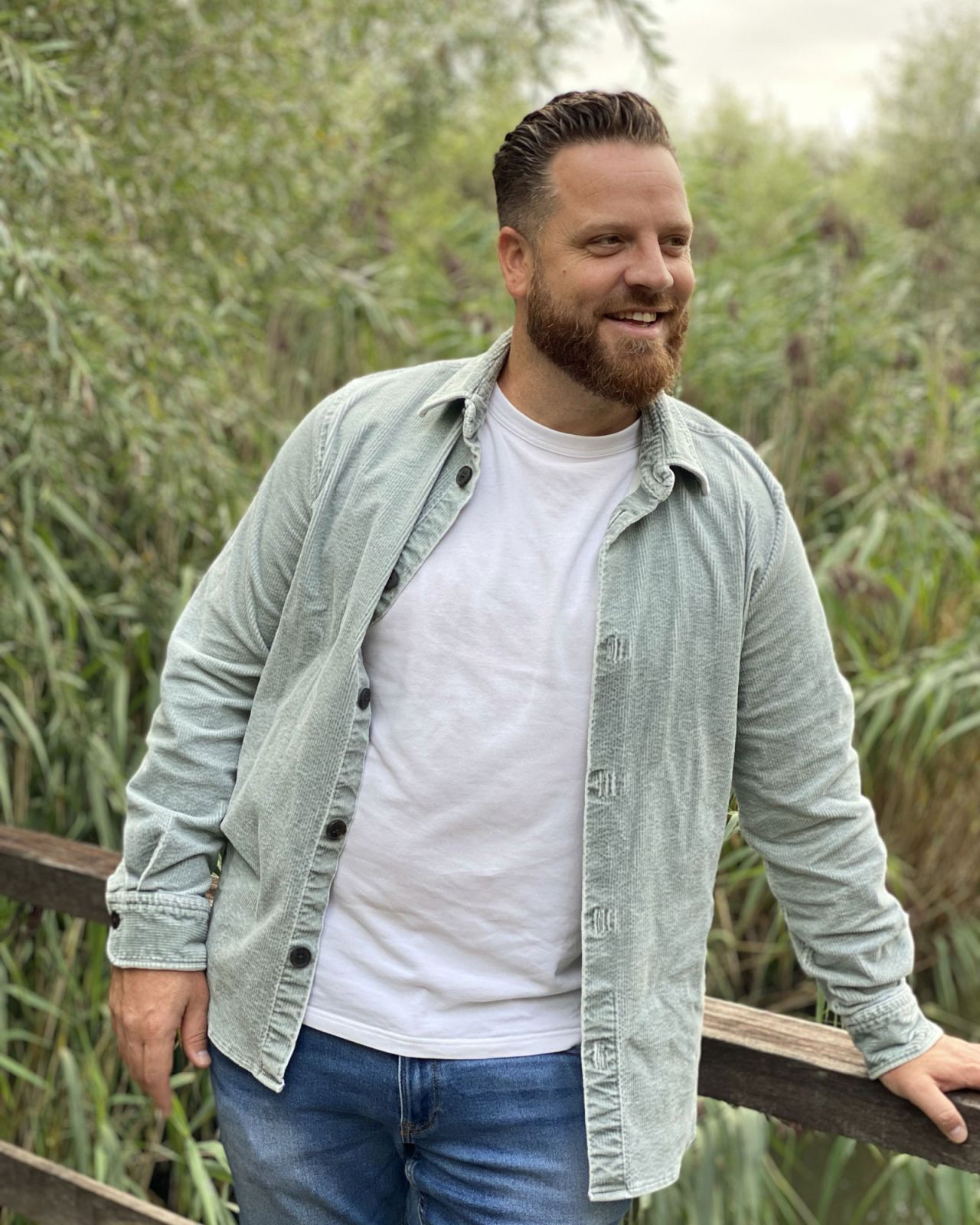 Roel leunend op houten brug in een groene, natuurlijke omgeving
